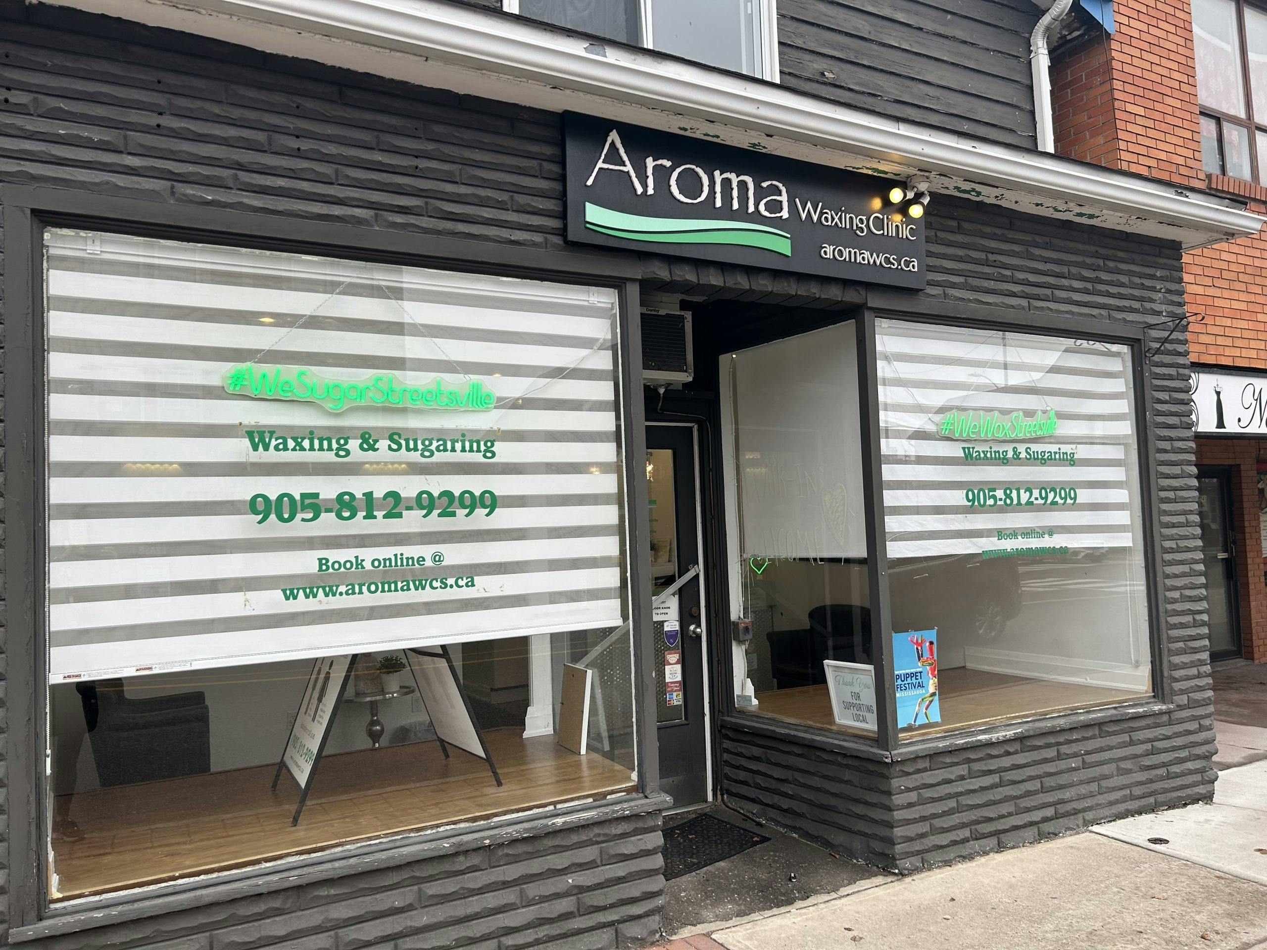 The storefront of Aroma Waxing and Laser Clinic (Streetsville location) with hours of operation, address, phone number, and email below