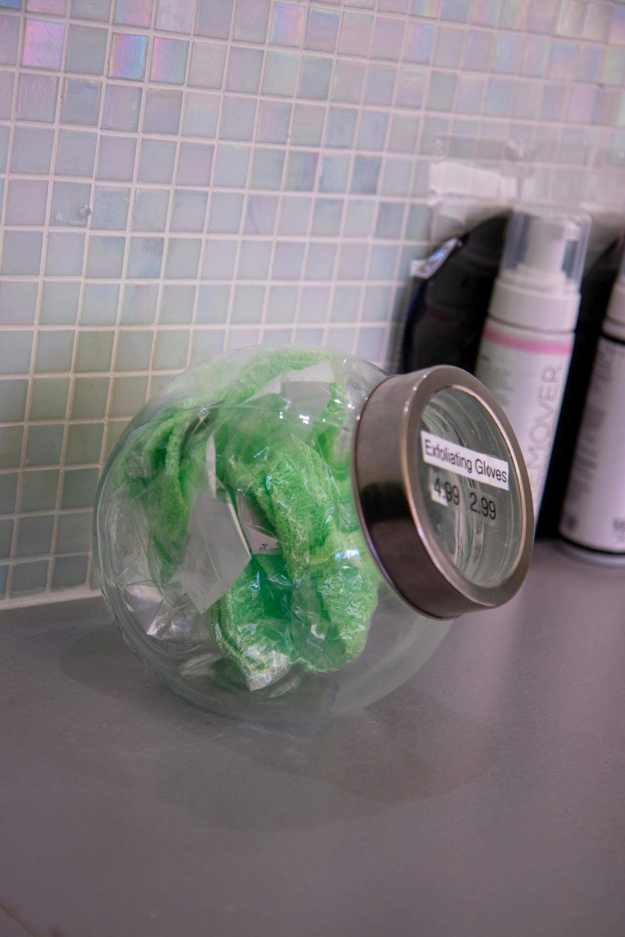 Green exfoliating gloves in a jar