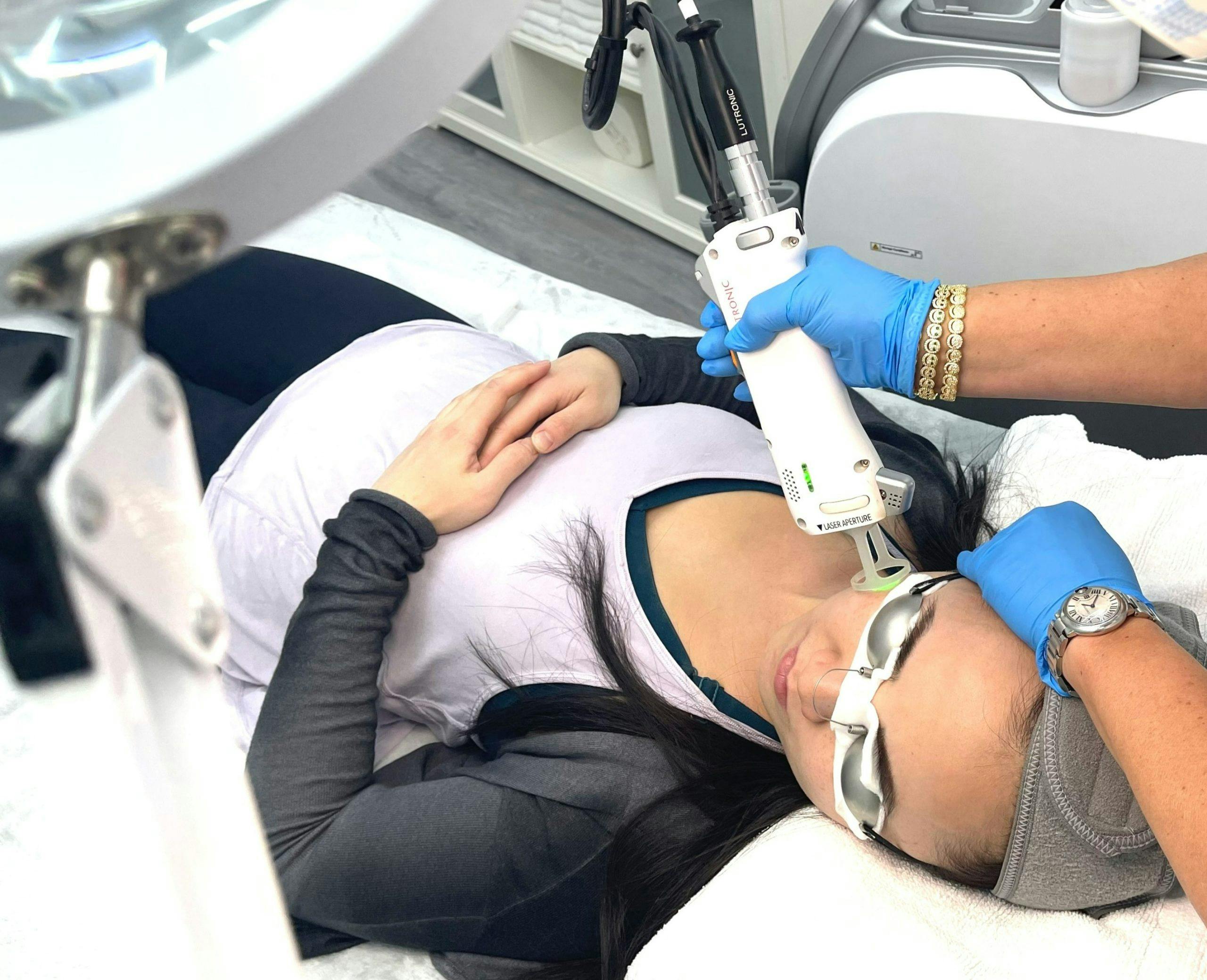 Laser technician performing pigmentation removal on a woman upper cheeks.